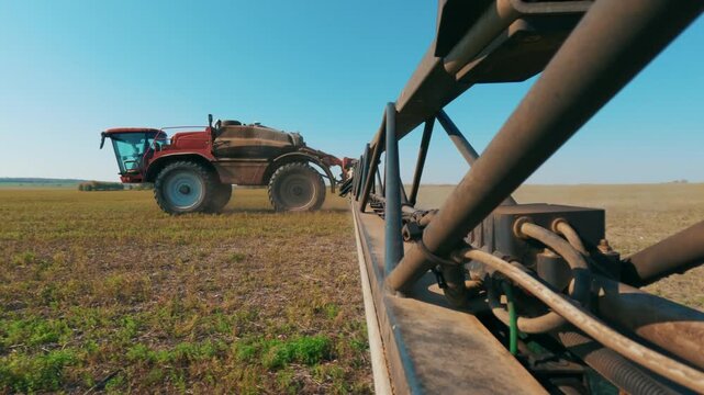 A cinematic shot of agricultural work featuring a self-propelled sprayer moving across the field to ensure accurate and even crop treatment. 