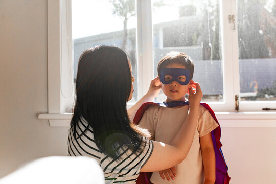 Asian mum help young son put on his mask