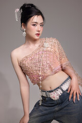 Modern trendy Thai fashion woman wearing a traditional Sabai paired with denim jeans, reflecting...