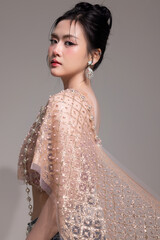 Modern trendy Thai fashion woman wearing a traditional Sabai paired with denim jeans, reflecting...