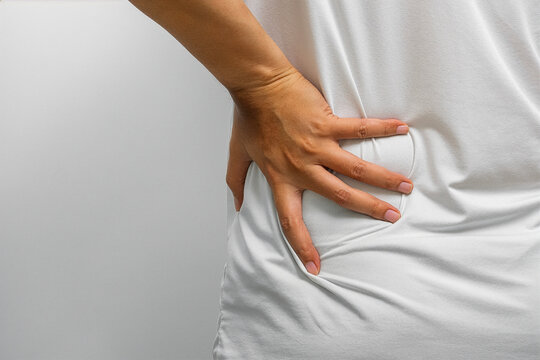 Lower back and hip pain with visible discomfort&mdash;muscle strain, spinal tension, or nerve pressure requiring physical therapy, orthopedic care, and wellness support.