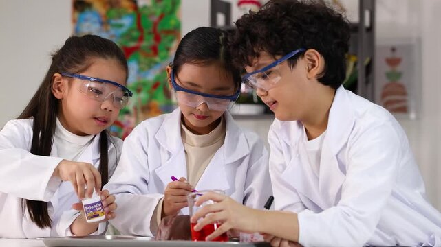 Asian Children in Lab Coats Conducting a Science Experiment in Classroom