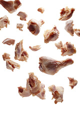 Raw chicken pieces, scattered, in mid-air