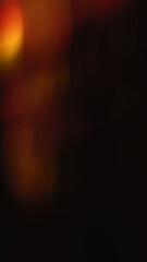 Naklejka premium Blurred gold crystal light leaks on black background. Defocused abstract yellow and orange retro film lens flare bokeh analog photo overlay, screen filter effect. Glow Vintage prism warm colors