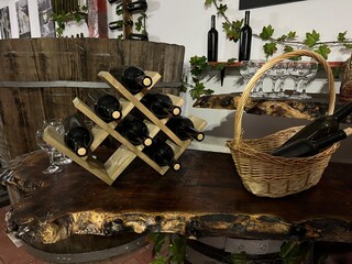 Traditional winery tasting area with handcrafted furniture and vintage decor. The scene shows an authentic wine storage room with barrels and shelves in a rural farm style.