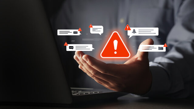 The businessman's hand is touching a virtual alert icon about threats from scams, viruses, and system threats, displaying fraudulent emails, malware, and phishing threats, and providing protection aga