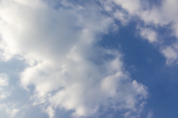 Fototapeta premium Wide angle shot of bright blue sky filled with soft white fluffy clouds, beautiful natural cloudscape background on a clear sunny day with vast copy space for graphic design.