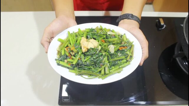 Delicious Stir-Fried Water Spinach with Garlic and Chili Served on a White Plate