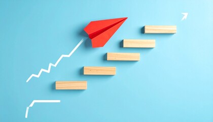 Conceptual image representing progress and aspiration, featuring a white zigzag staircase line on a blue background with five wooden rectangular blocks placed at each step; a red paper airplane positi