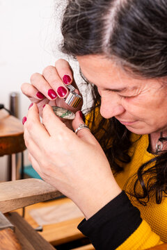 Jewelry Maker Cheks on a Piece of Variscite Stone in a Workshop During the Day