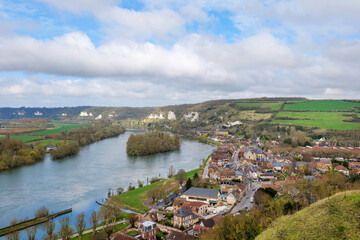 Fototapeta premium Scenic view of Les Andelys village in France from Chateau Gaillard, early spring with fresh greenery, historic buildings and river visible, village showcasing French countryside charm