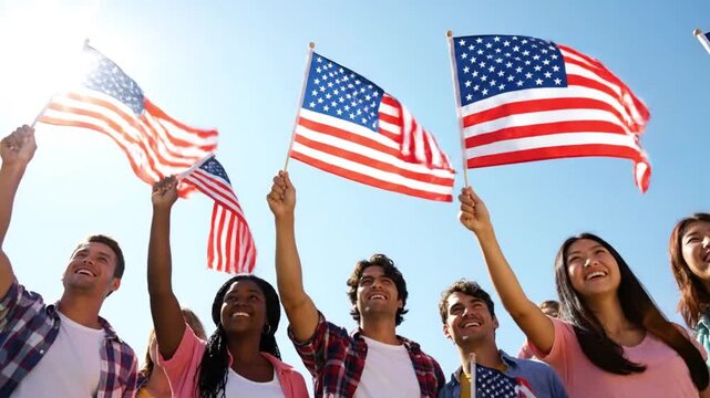Diverse group of young people joyfully waving American flags under a bright blue sky, celebrating freedom and unity.