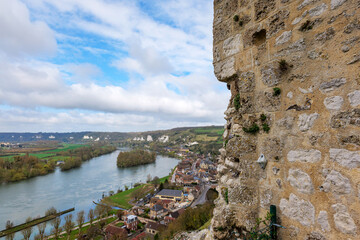 Fototapeta premium Panoramic townscape of Les Andelys from Chateau Gaillard, spring season with emerging green foliage, river flowing through town, historic architecture highlighting French heritage