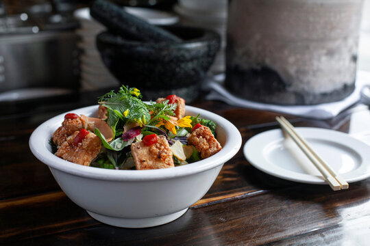 Bowl of fried tofu and leafy greens at restaurant