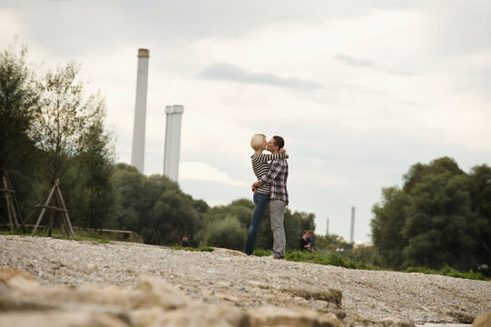 Romantic couple kissing and hugging by riverfront in city