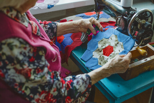 An elderly woman looks at her handicrafts