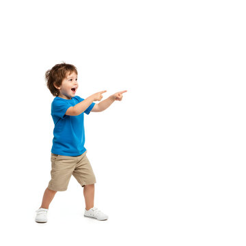 Curious little boy pointing his finger at empty copy space, surprised child showing something interesting, discovery and childhood wonder concept