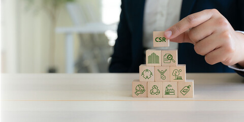 CSR (Corporate Social Responsibility) corporate sustainability concept. Stacking wooden blocks into...