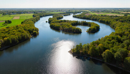 Obraz premium river making a sharp meander through farmland and forest. High sun, crisp tree shadows, the water brightly reflecting the sky