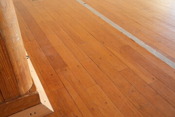 A wooden floor with a white line running down the middle. The floor is made of wood and has a light brown color