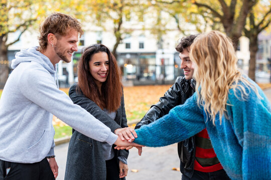 Friends collaborating and smiling outdoors in autumn park