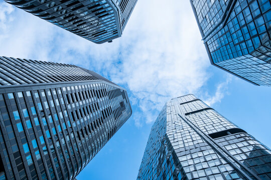 Glass skyscraper seen from upward perspective under blue sky in urban frankfurt germany showcasing sleek architecture and towering city height