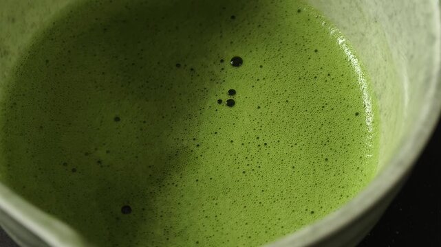 Process making matcha green tea. Mixing matcha tea with whisk in wooden bowl. Healthy matcha drinks