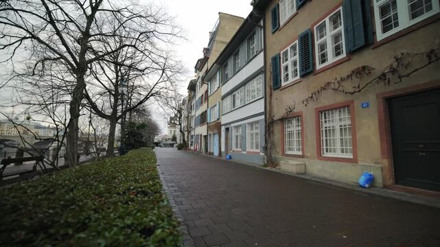 Cinematic pan of traditional colorful historic houses along the Oberer Rheinweg at the Rhine river in Basel, Switzerland.