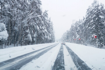 Obraz premium Cars on a snowy winter road. Winter car travel on forest roads.