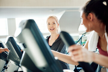 Fototapeta premium Fitness, friends and talking on machine in gym, workout activity or performance for endurance challenge. Training buddy, conversation or women on stair climber for cardio exercise, active or support