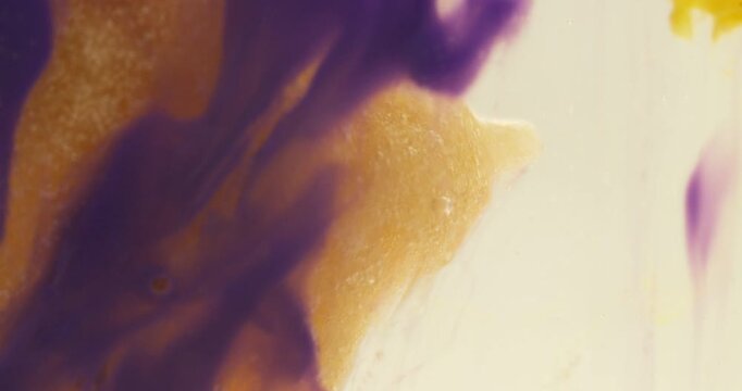 Macro abstract of colorful bath bomb dissolving in water with organic ink flow and fizzing bubbles