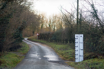 Naklejka premium winding countryside road with flood marking warning