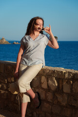 Close up portrait of a girl with closed eyes enjoying the summer sunset on the coast, travel and relaxation concept.