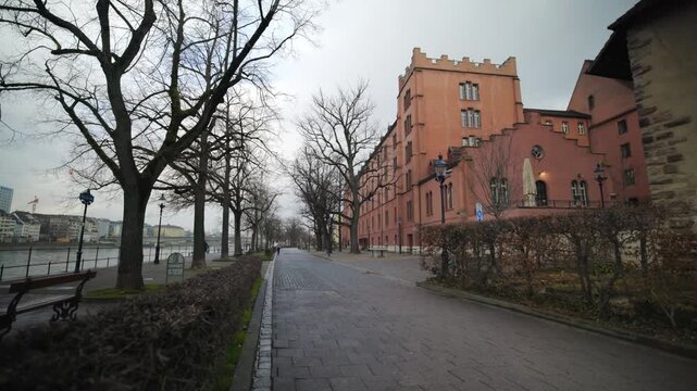 Historical Kaserne building complex with pan along the Rhine river promenade in Basel, Switzerland.