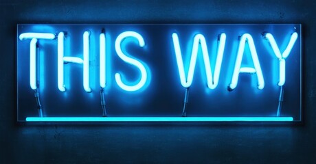 Bright neon sign displays words THIS WAY. Blue glow contrasts dark textured wall. Simple directional message.