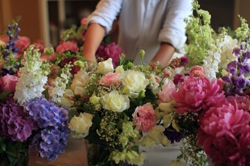 Caucasian young adult arranging colorful floral bouquets in a bright studio