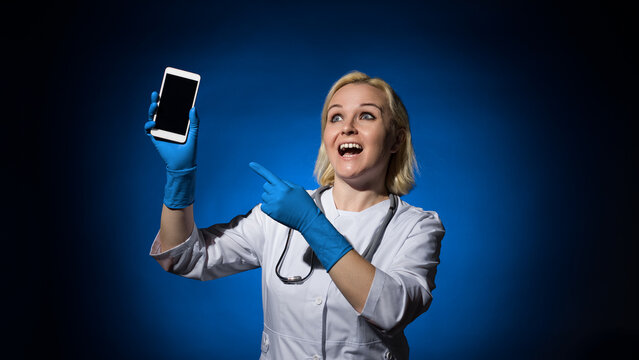 female doctor in blue gloves with a smartphone in her hands