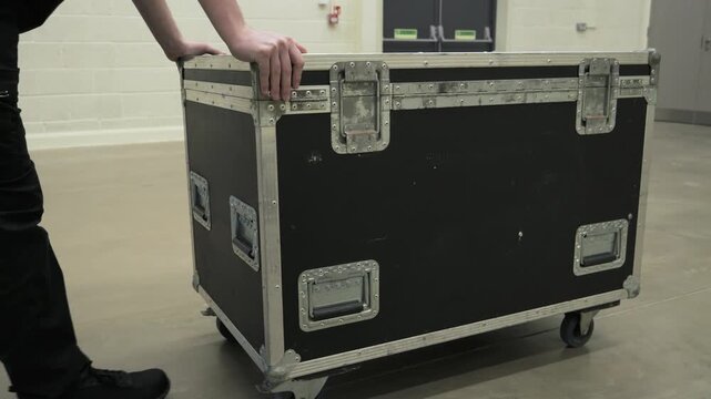 Roadie pushing a heavy flight case Trunk backstage