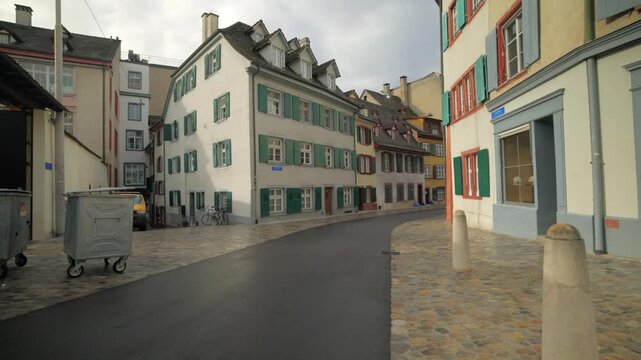 Cinematic pan of a quiet historical cobblestone street in Basel old town, Switzerland.