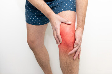 Knee pain, man holding his injured knee