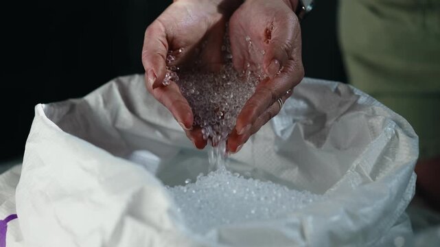 Hand of woman hold polymer granules PVC after recycle plastic plant industry. Concept ecology environmental protection.