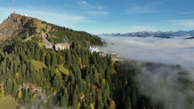 Drone view of mountain top hotel and railway above se of fog