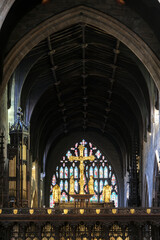 Interior of Newcastle Cathedral with Gothic arches, altar, stained glass, and nativity scene.