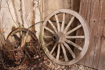 old wooden wheel near the wooden fence