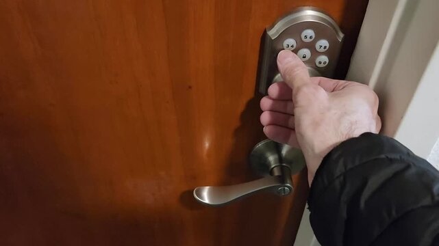 Male hand pressing keypad buttons with thumb