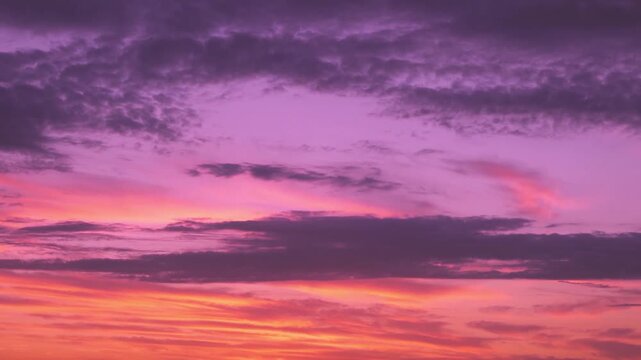 Incredible bright orange lilac yellow sunset skyscraper sun and cirrus clouds dusk time lapse, motion, aerial view. Colorful sky clouds in sunlight sun rays sunbeams, colored sky background 4K.