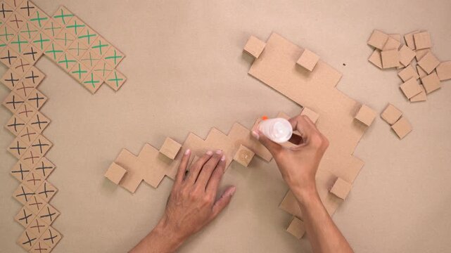 Glueing cardboard pickaxe art together, top down