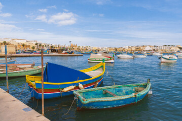 Colorful traditional Luzzu boats at Marsaxlokk harbor, Malta. Perfect for travel blogs, Mediterranean tourism campaigns, and European vacation marketing materials.