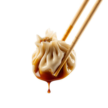 A delicious single steamed dumpling covered in rich dark sauce held by wooden chopsticks with a drip, isolated on transparent background