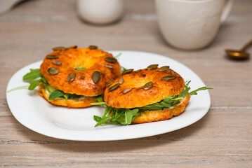 Bagels with cream cheese, fish, pumpkin seeds and arugula.